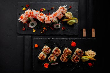 top view of roll in mamenori with shrimp, salmon and avocado in sauce nigiri and roll with creamy eel and kimchi mayonnaise  clipart