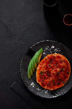 Okonomiyaki, dilimlenmiş avokado ile geleneksel Japon lezzetli gözleme ve balık sosu ile üstten görünüm