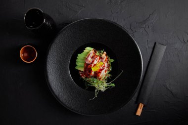 Japon Ceviche siyah plaka üzerinde üstten görünüm deniz ürünleri, avokado ve otlar ile 
