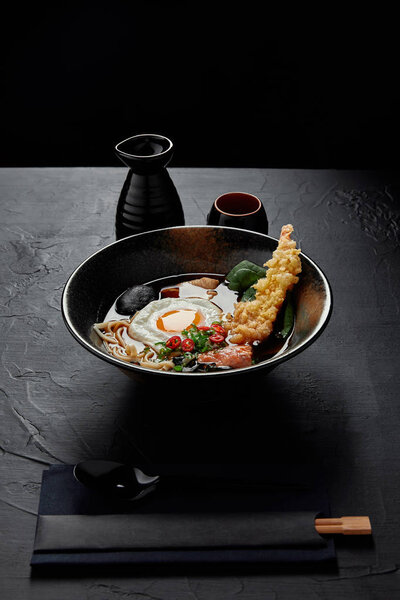 bowl with gourmet traditional japanese soup with egg, noodles and mushrooms