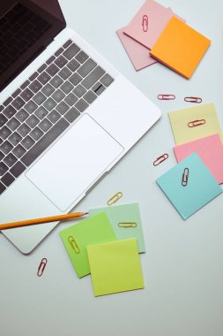 beyaz masa üzerinde laptop, Kağıt etiketleri, kalem ve kağıt klipleri yükseltilmiş görünümü