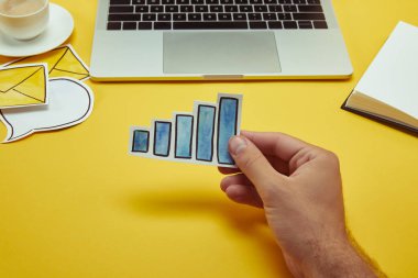 Kağıt grafik işareti dizüstü yakınındaki tutan adamın kırpılmış görüntü