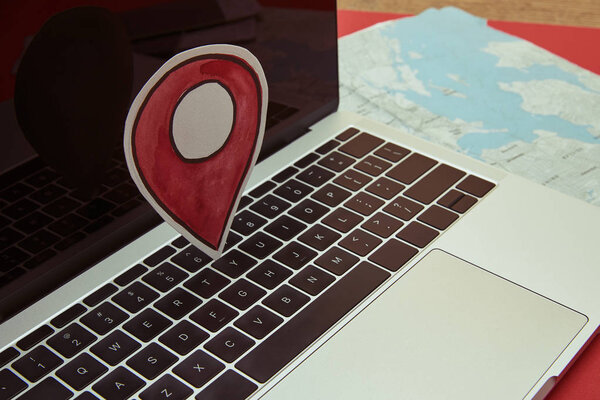 gps location sign on laptop, map on tabletop