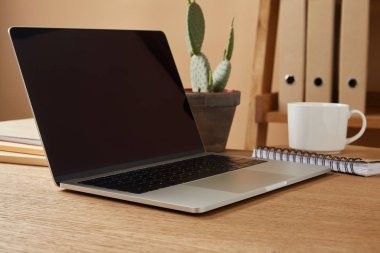 Laptop ile boş bir ekran ve kahve masasında 