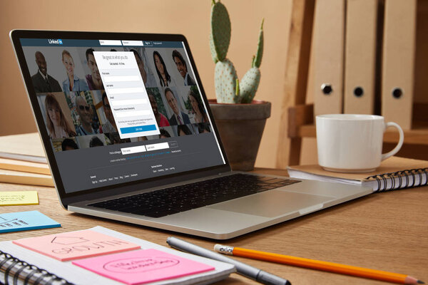 ноутбук с загруженной страничкой linkedin на столе дома
