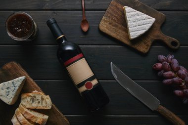 şarap şişesi boş etiket, bıçak ve lezzetli aperatifler ile üstten görünüm ahşap tablo