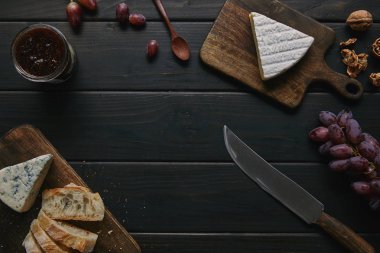 ahşap masa üzerinde bıçak, lezzetli reçel ve gurme atıştırmalıklar üstten görünüm