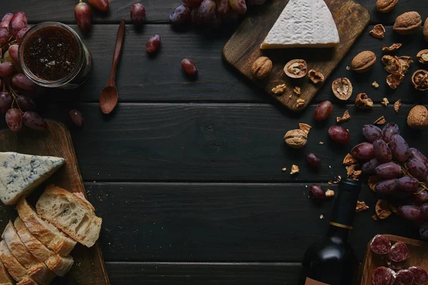 Ahşap Masa Üzerinde Şarap Şişesi Çeşitli Lezzetli Aperatifler Üstten Görünüm — Stok fotoğraf