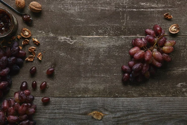 木製のテーブルに新鮮な熟したブドウ クルミ おいしいジャムの上から見る — ストック写真