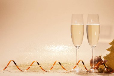 Noel oyuncaklar, dekoratif yıldız ve iki bardak şampanya ile masa üzerinde glitter