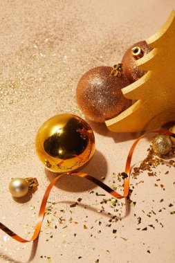 Masa üzerinde Noel topları, dekoratif Noel ağacı, dalgalı şerit ve glitter yüksek açılı görünüş