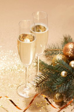 Altın Noel topları, çam dal ve bardak şampanya masa üzerinde