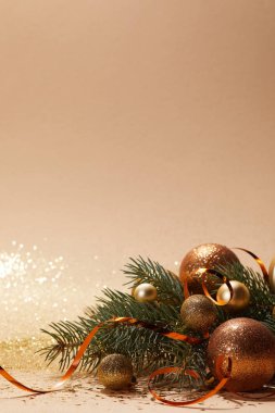 glittering golden christmas balls and christmas tree branch on tabletop clipart