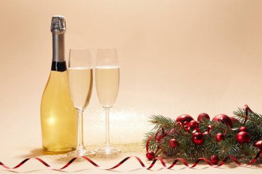 şişe ve kadeh şampanya, Noel topları ve ışıltılı masa üstü çam dalı