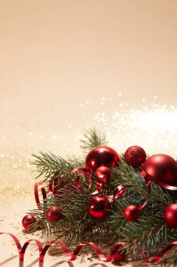 kırmızı parlak Noel oyuncaklar, dalgalı şerit ve parlak yüzeyi çam dalı