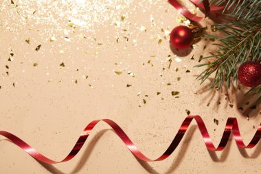 kırmızı parlak Noel topları, kırmızı dalgalı şerit ve çam dalı parlak yüzeyi
