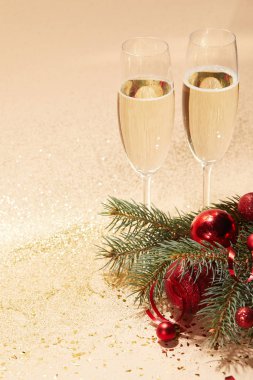 bardak şampanya, kırmızı parlak Noel topları ve altın masa üstü Parlatıcı üzerinde çam dalı