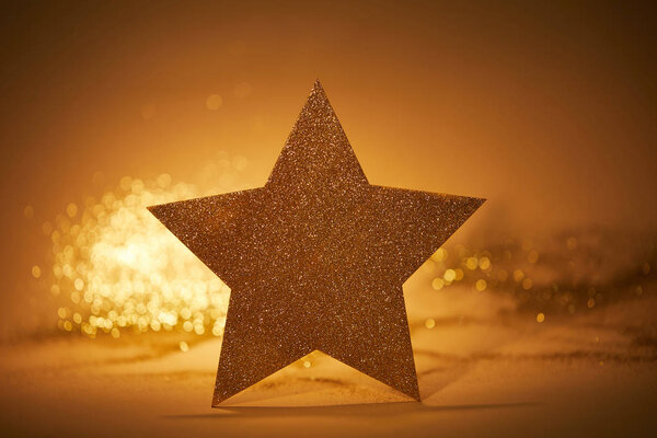 золотая блестящая звезда для рождественского украшения на столе
