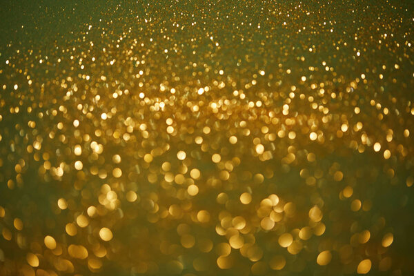 golden and green bokeh christmas background with glossing sequins