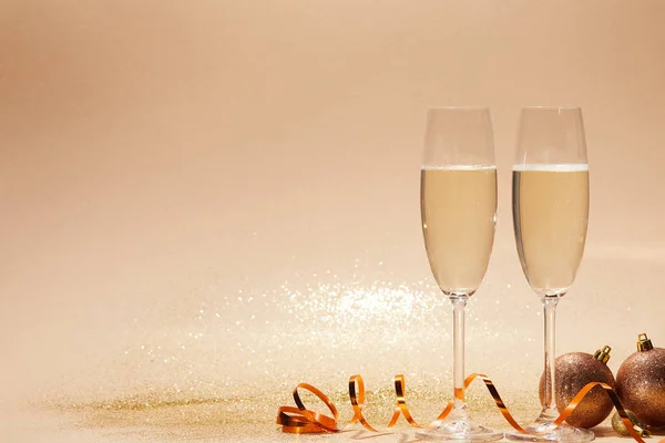 Kerstballen Golvende Lint Twee Glazen Champagne Met Glitters Tafelblad — Stockfoto