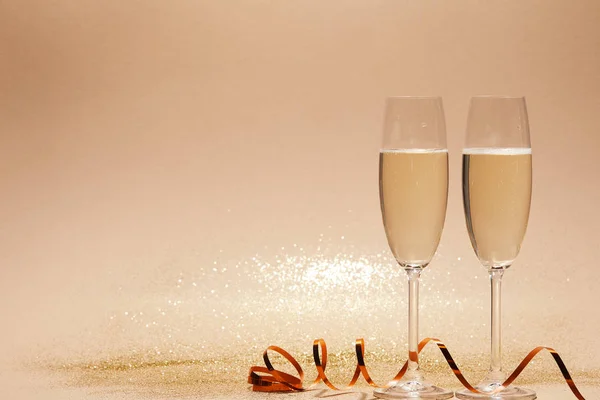 Welliges Band Und Zwei Gläser Champagner Mit Glitzern Auf Tischplatte — Stockfoto
