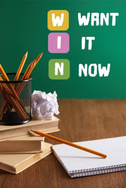 books, copybook, crumpled paper and pencils on wooden table with 