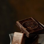 Nahaufnahme von Gourmet-Schokoladenstücken im Glas auf dunklem Hintergrund