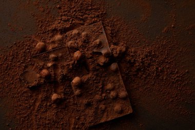 top view of delicious chocolate pieces with nuts on dark background clipart