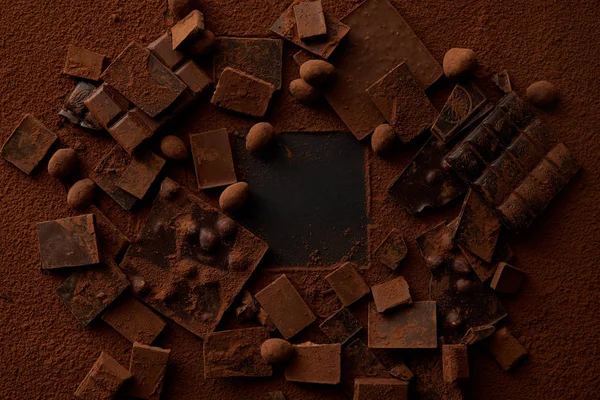 Bovenaanzicht Van Chocoladestukjes Met Noten Cacao Poeder Donkere Achtergrond — Stockfoto