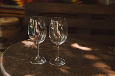 close-up shot of glasses for wine on rustic wooden table clipart