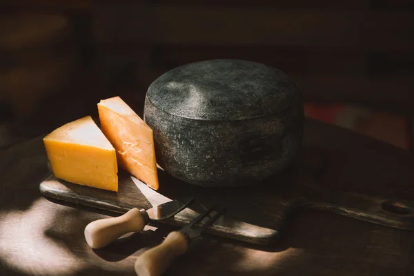 乡土木桌上的两种奶酪和餐具 — 图库照片
