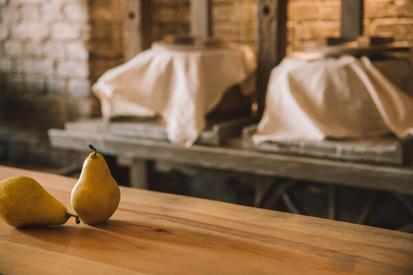 ripe pears on rustic wooden table at cheese manufacture