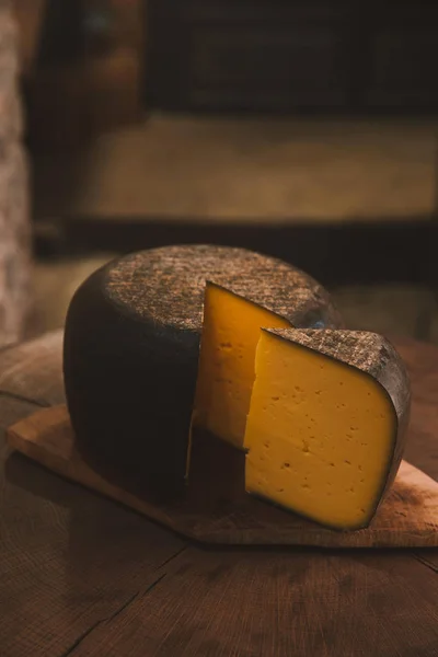 精致的切片干酪在仿古木制板材上 — 图库照片