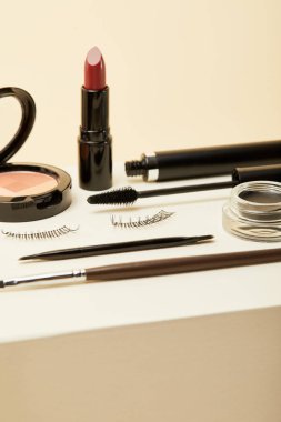 close-up shot of various makeup accessories on beige clipart