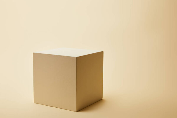 close-up shot of single cube on beige surface