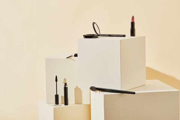 various makeup supplies lying on beige cubes