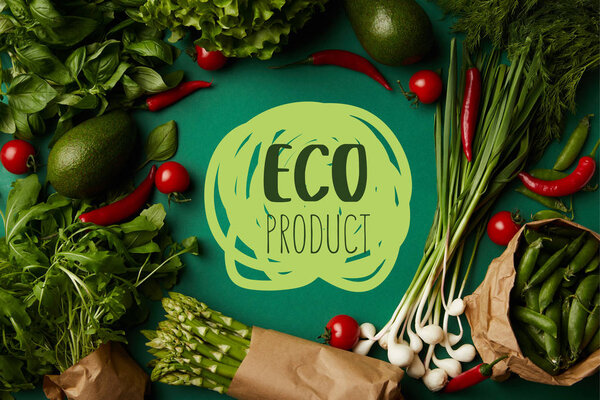 top view of round frame made of various ripe vegetables on green surface with "eco product" lettering