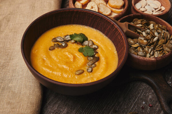 close-up view of bowl with tasty healthy pumpkin soup on rustic wooden table