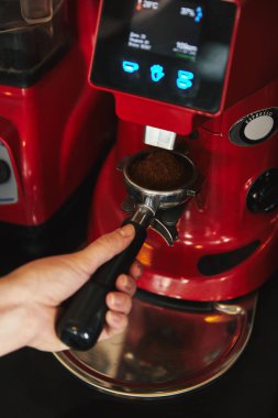 close-up partial view of barista preparing espresso in coffee machine  clipart