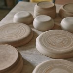 Close up view of plates at table in pottery studio