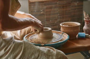 cropped image of professional potter working on pottery wheel at workshop clipart