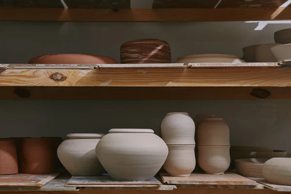 Keramikschalen Und Geschirr Auf Holzregalen Töpferatelier — kostenloses Stockfoto