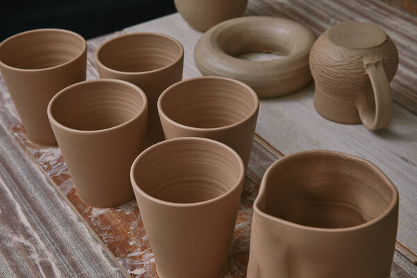 selective focus of ceramic pots at table in pottery studio