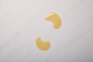 top view of spilled yellow soap on white marble clipart