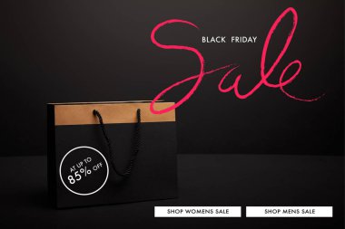 close up view of paper shopping bag on black backdrop with black friday sale clipart