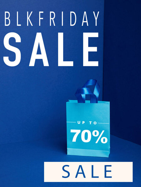 close up view of paper shopping bag on blue with blkfriday and 70 percents sale