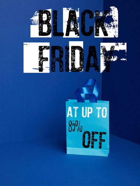 close up view of paper shopping bag on blue with black friday and 85 percents off discount