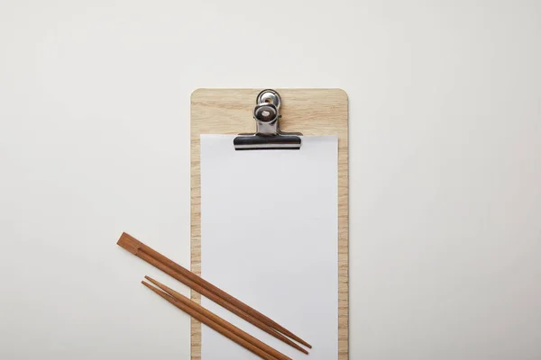 Επίπεδη Lay Κενό Μενού Και Chopsticks Λευκή Επιφάνεια Μινιμαλιστική Έννοια — Δωρεάν Φωτογραφία
