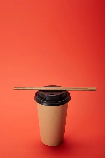 Nahaufnahme Von Essstäbchen Auf Pappbecher Kaffee Auf Rotem Minimalistischem Konzept — Stockfoto