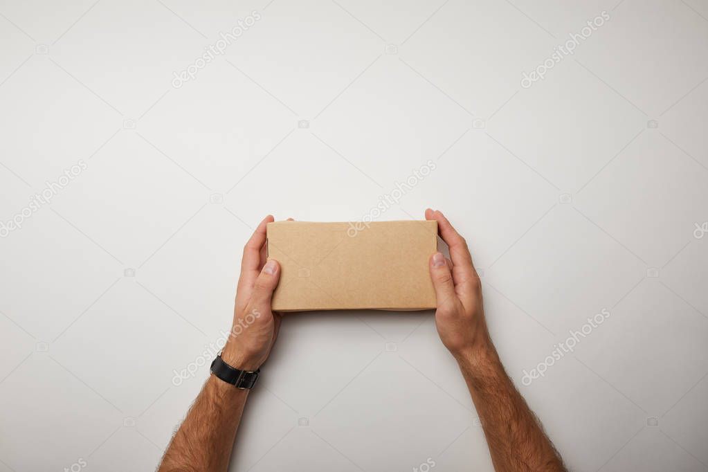 cropped image of man holding delivery food box on white surface 